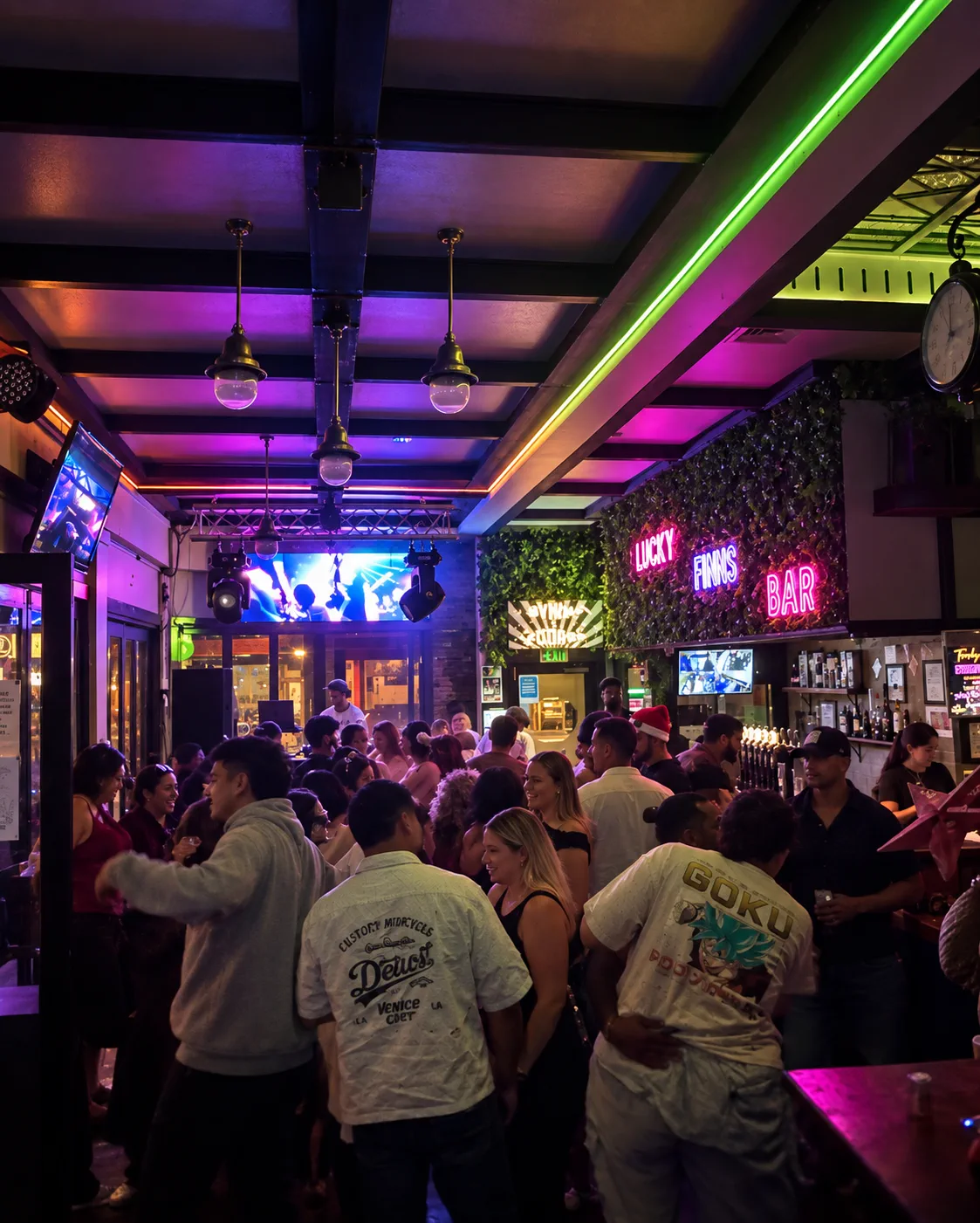 A busy night inside Lucky Finns with neon signs and a crowd